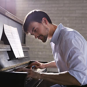 Berufshaftpflichtversicherung Musiklehrer - Musiklehrer am Klavier