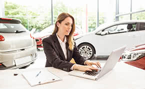Betriebshaftpflichtversicherung Autohäuser - Autohändlerin am Laptop